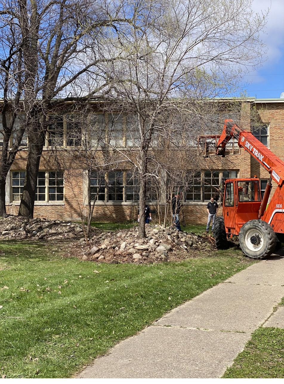 Community members and trades volunteers clearing and restoring the grounds at the future AC3 Community Center